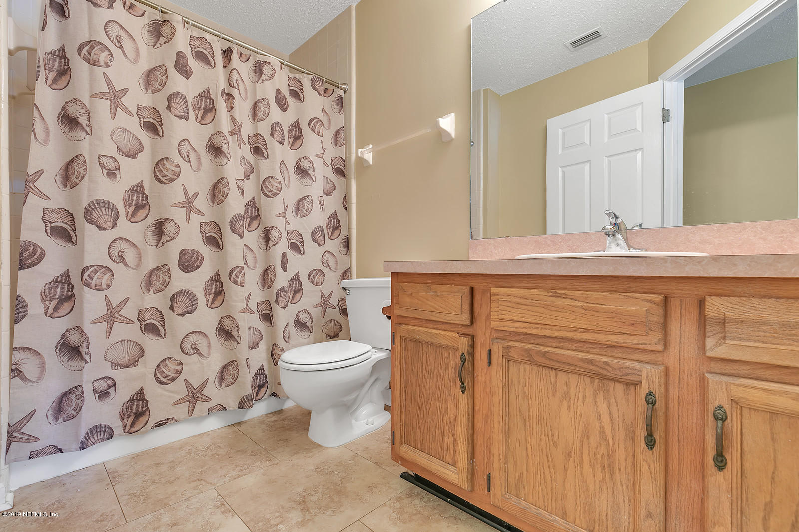 12436 Running River Road South Jacksonville, FL 32225 - Photo 19 of 25 a bathroom with a granite countertop sink a toilet and a mirror