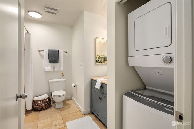 a balcony with couple of chairs a barbeque and a stove