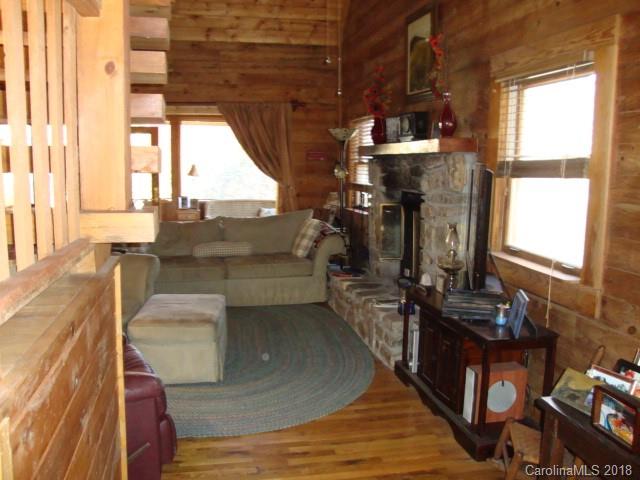 249 Nottingham Road, Unit 10 Maggie Valley, NC 28751 - Photo 12 of 24 a living room with couches bookshelf and a stove with wooden floor