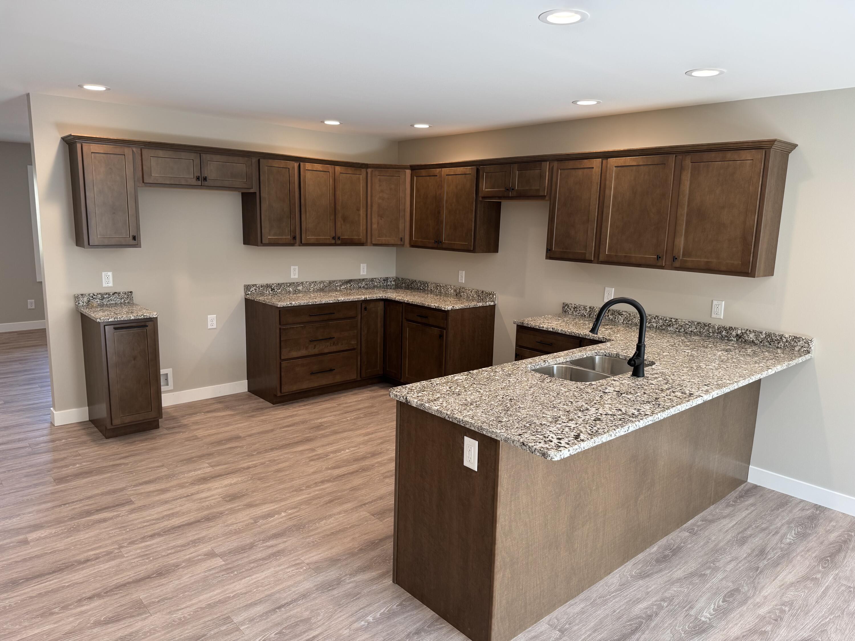 821 9th Street Southwest, Unit 10B De Motte, IN 46310 - Photo 7 of 17 a kitchen with stainless steel appliances granite countertop a sink dishwasher a stove and a refrigerator with wooden floor