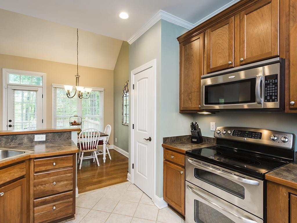 2502 Hopkins Road Bahama, NC 27503 - Photo 8 of 24 a kitchen with stainless steel appliances granite countertop a stove top oven a sink dishwasher a dining table and chairs with wooden floor