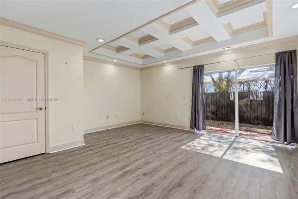 a view of a kitchen with wooden floor and a refrigerator