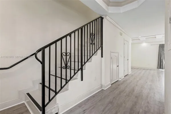 a view of a hallway with wooden floor and staircase