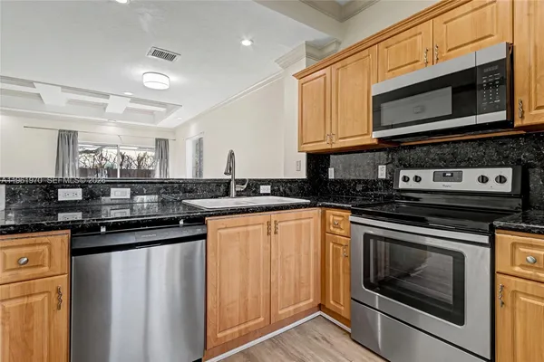 a kitchen with stainless steel appliances granite countertop a refrigerator microwave and sink