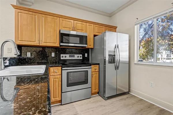a kitchen with stainless steel appliances granite countertop a stove a sink and a microwave