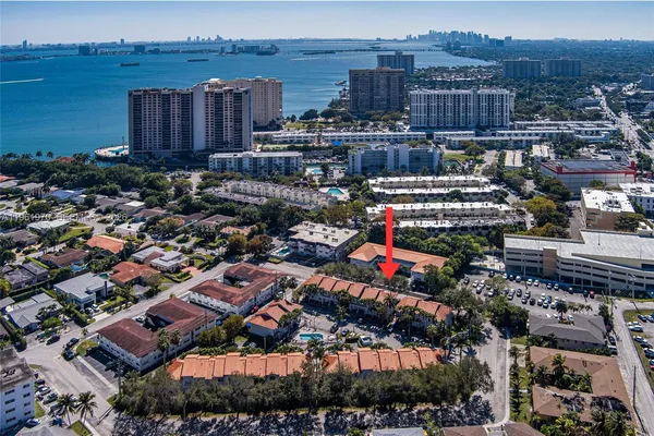 a living room with furniture a rug and kitchen view