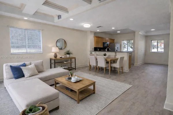 a view of a big room with wooden floor and a kitchen