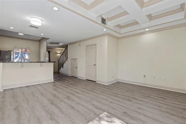 a view of a kitchen with wooden floor and electronic appliances