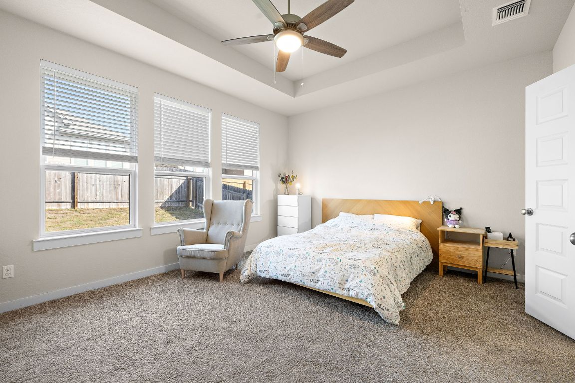 120 Upland Drive Georgetown, TX 78628 - Photo 10 of 21 Carpeted bedroom featuring a raised ceiling and a ceiling fan