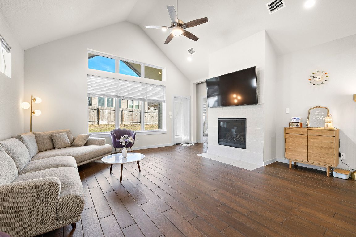120 Upland Drive Georgetown, TX 78628 - Photo 5 of 21 Living room featuring high vaulted ceiling, a fireplace, dark wood-style flooring, and ceiling fan