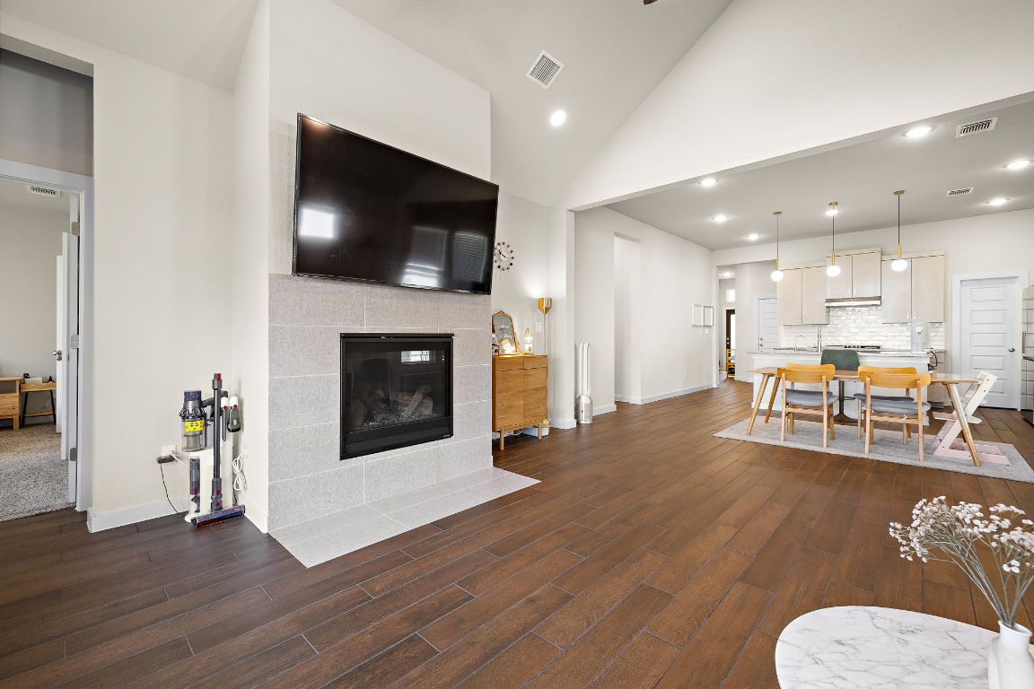 120 Upland Drive Georgetown, TX 78628 - Photo 6 of 21 Living room featuring a tiled fireplace, recessed lighting, dark wood-style flooring, and high vaulted ceiling