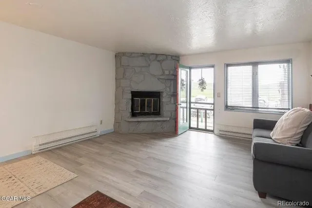 wooden floor fireplace and windows in an empty room