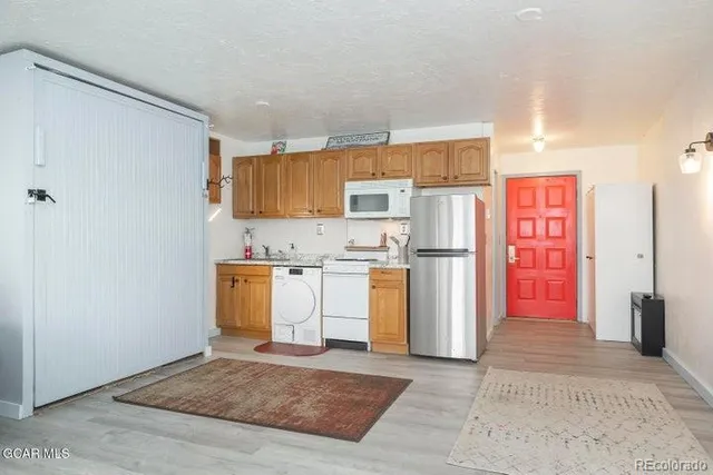a view of kitchen with furniture and refrigerator