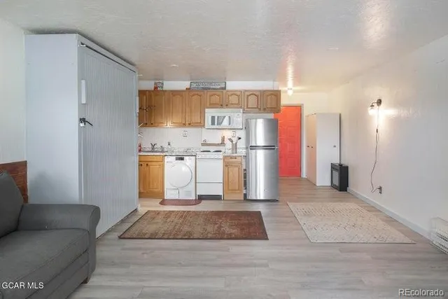 a kitchen with stainless steel appliances granite countertop a refrigerator a stove and a sink