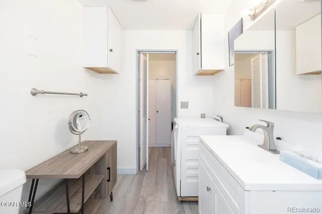 a bathroom with a sink a light fixture and a mirror