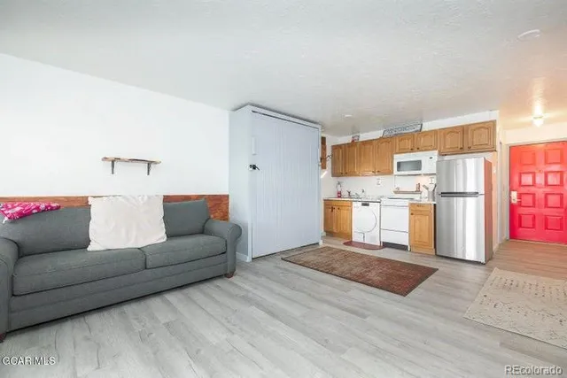 a living room with furniture and kitchen view