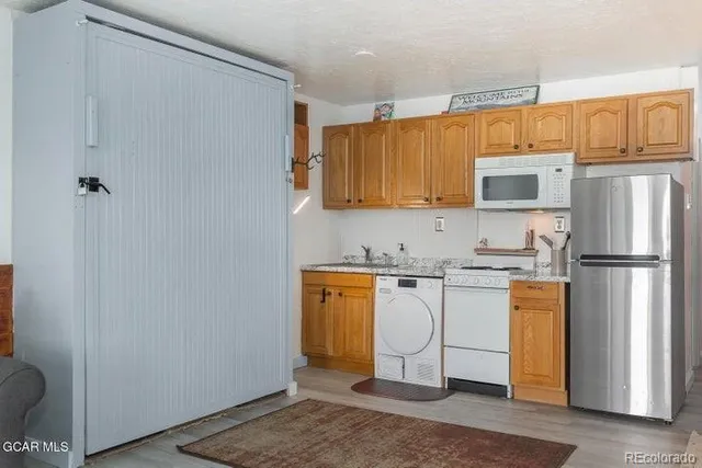 a kitchen with stainless steel appliances granite countertop a refrigerator a stove top oven a sink and dishwasher