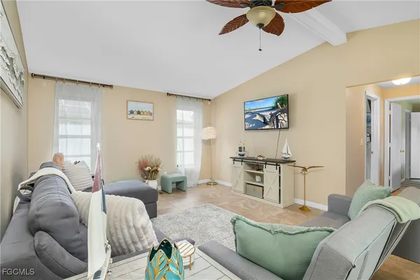 a living room with furniture kitchen view and a window
