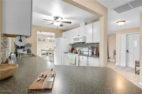 a kitchen with refrigerator and white cabinets