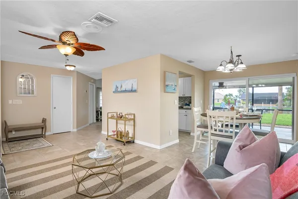 a living room with furniture a chandelier and a floor to ceiling window