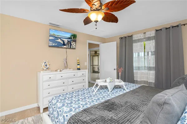 a bedroom with a bed and a chandelier fan