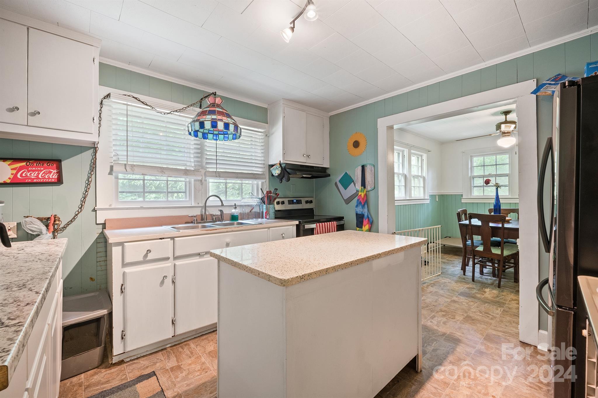 2711 Ellerwood Road Hudson, NC 28638 - Photo 8 of 19 a open kitchen with kitchen island a stove a sink a dining table and chairs with wooden floor