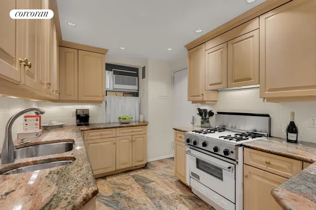 a kitchen with granite countertop a sink a stove and cabinets