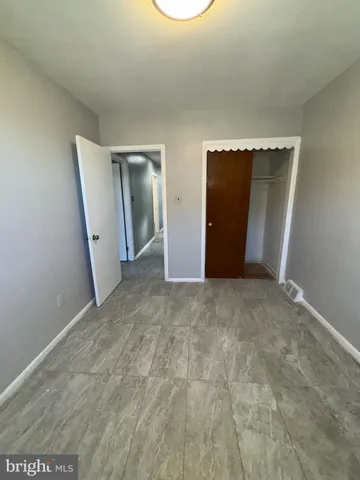 an empty room with closet and mirror