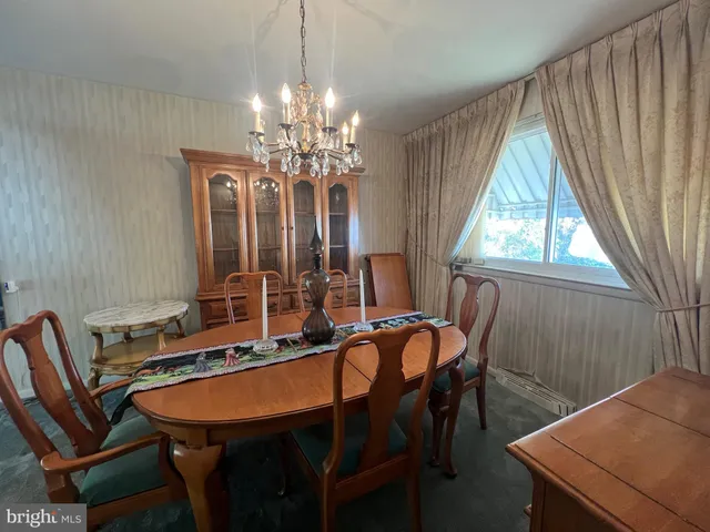a dining room with furniture a chandelier and window