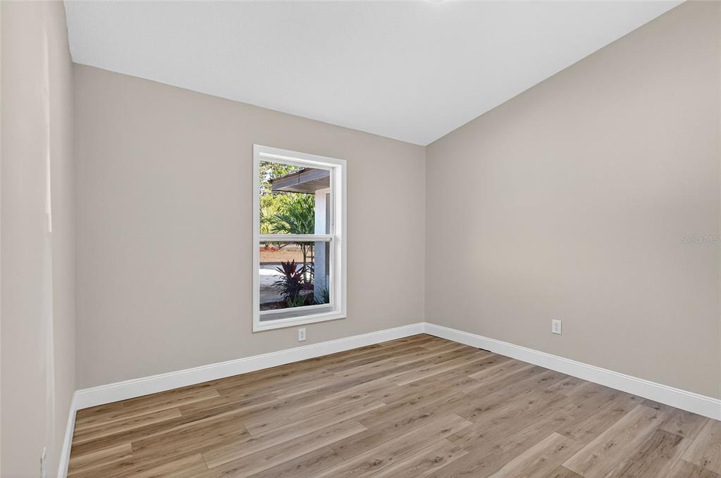 7078 South Threshold Point Homosassa, FL 34446 - Photo 18 of 75 a view of an empty room with wooden floor and a window