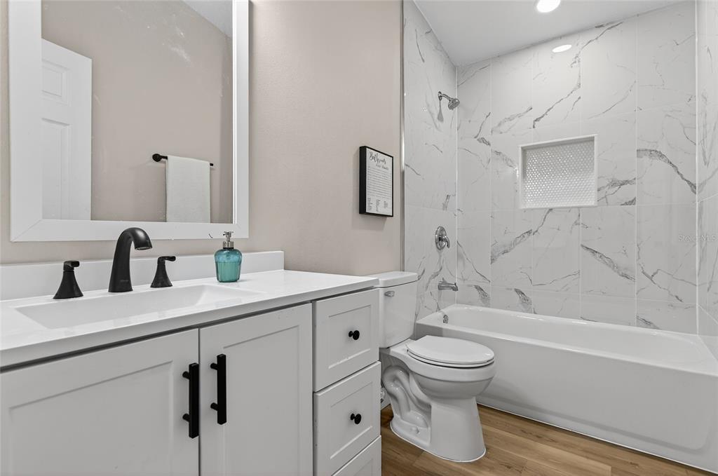 7078 South Threshold Point Homosassa, FL 34446 - Photo 19 of 75 a bathroom with a bathtub shower sink vanity mirror and toilet