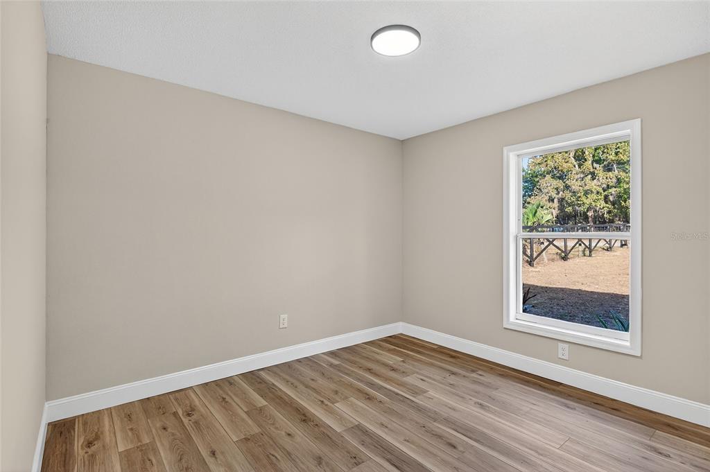 7078 South Threshold Point Homosassa, FL 34446 - Photo 25 of 75 a view of an empty room with wooden floor and a window