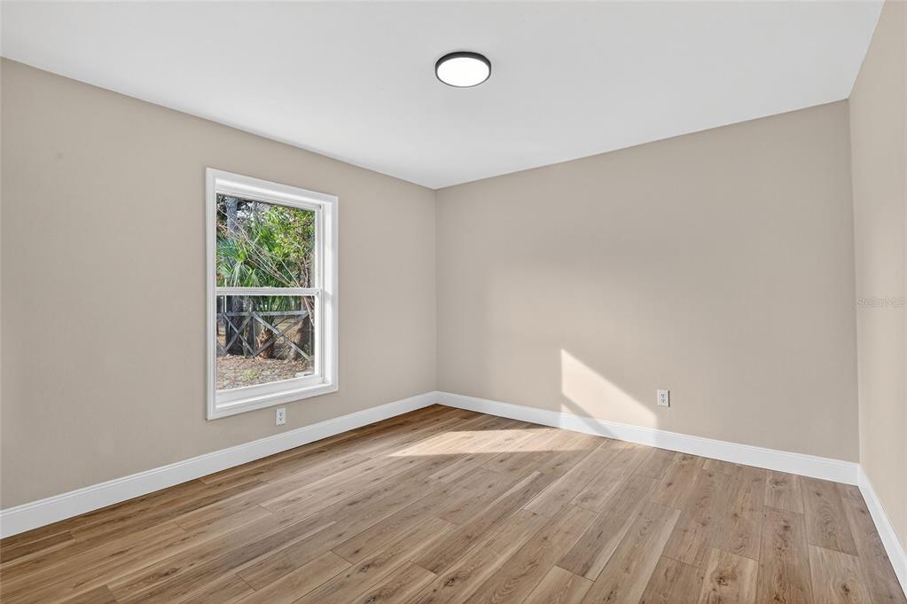 7078 South Threshold Point Homosassa, FL 34446 - Photo 28 of 75 an empty room with wooden floor and windows