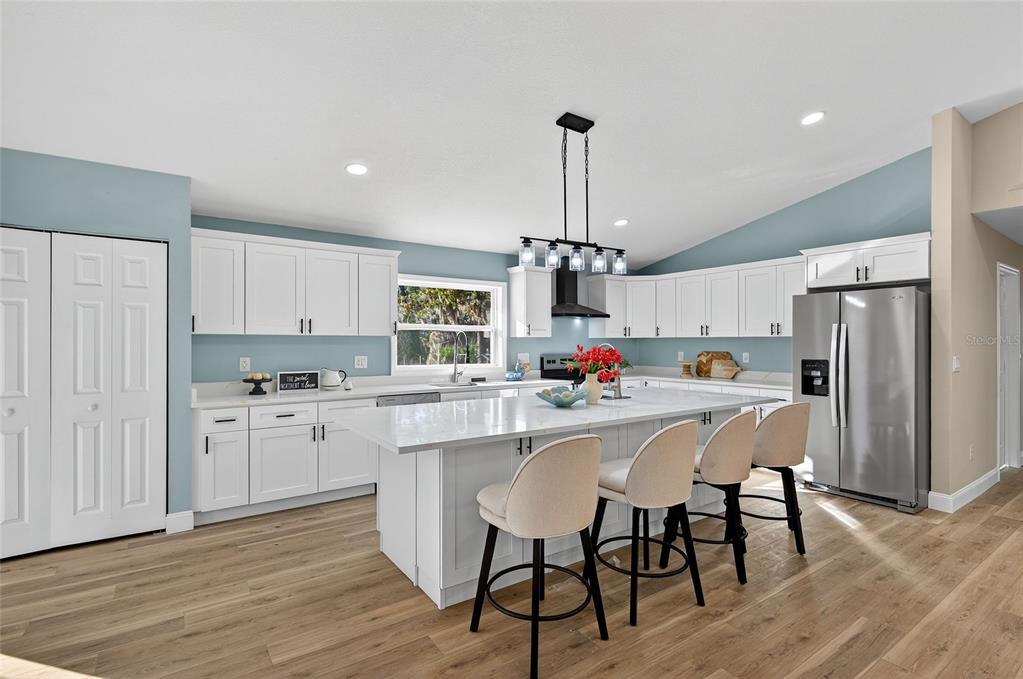 7078 South Threshold Point Homosassa, FL 34446 - Photo 10 of 75 a kitchen with stainless steel appliances kitchen island granite countertop a dining table chairs and white cabinets
