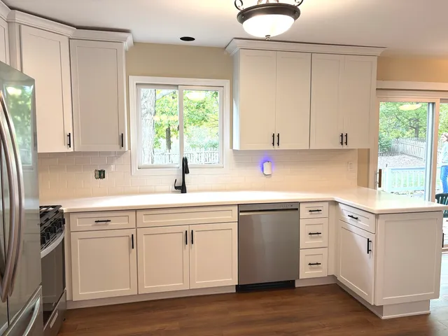 a kitchen with a sink cabinets appliances and a window