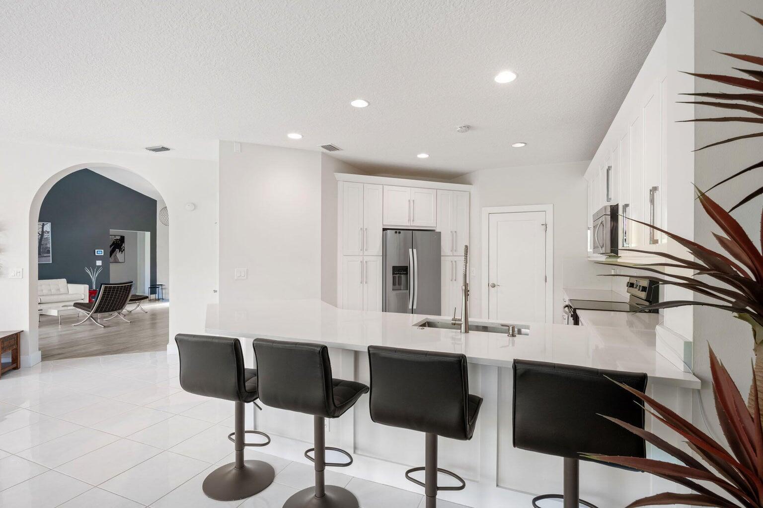 10982 Ravel Court Boca Raton, FL 33498 - Photo 13 of 43 a kitchen with stainless steel appliances kitchen island granite countertop a sink and cabinets