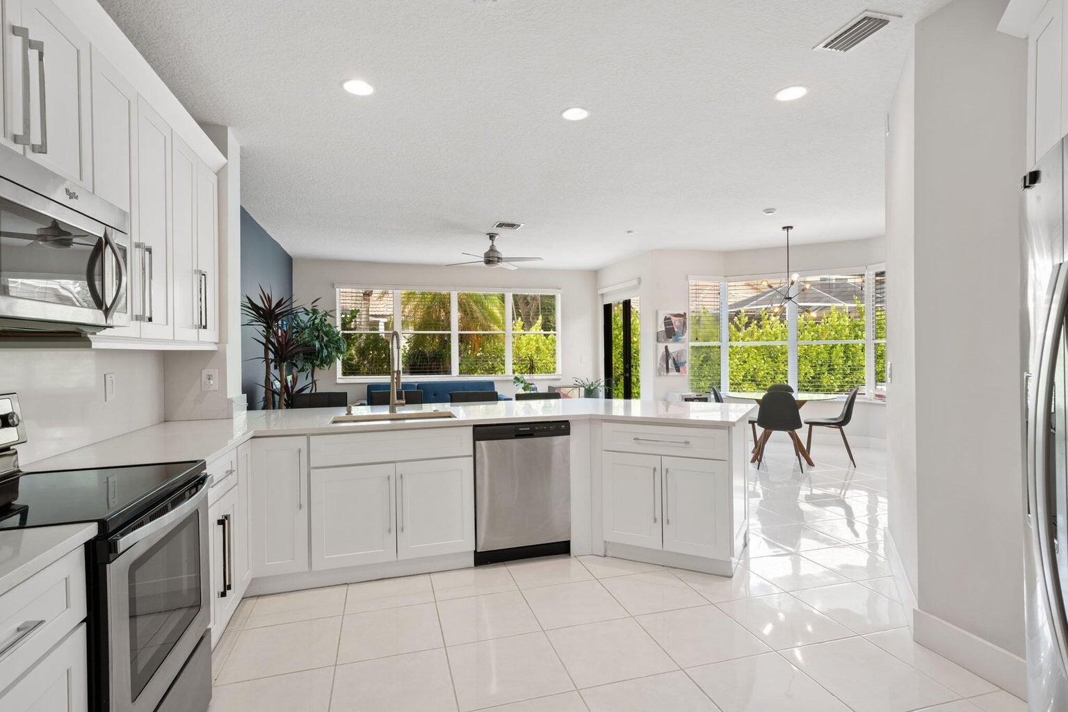 10982 Ravel Court Boca Raton, FL 33498 - Photo 15 of 43 a kitchen with stainless steel appliances granite countertop a stove and a sink