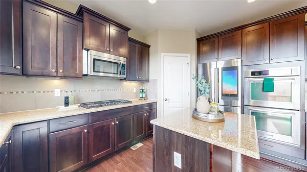 a kitchen with stainless steel appliances granite countertop wooden cabinets and sink