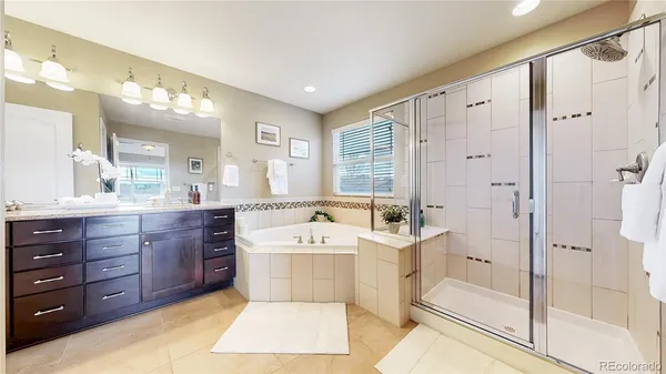 a spacious bathroom with a tub sink mirror and shower