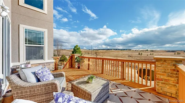 a view of a patio with couches chairs and wooden floor
