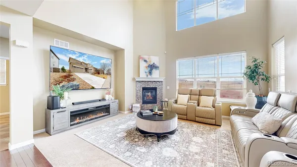 a living room with furniture a flat screen tv and a large window