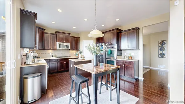 a kitchen with granite countertop appliances and a dining table