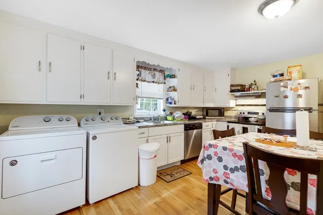 a kitchen that has a lot of cabinets in it and wooden floors
