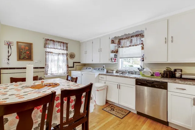 a kitchen with granite countertop a sink stove and white cabinets