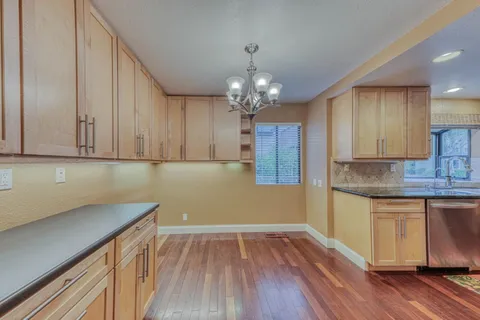a kitchen with stainless steel appliances a refrigerator and wooden floor