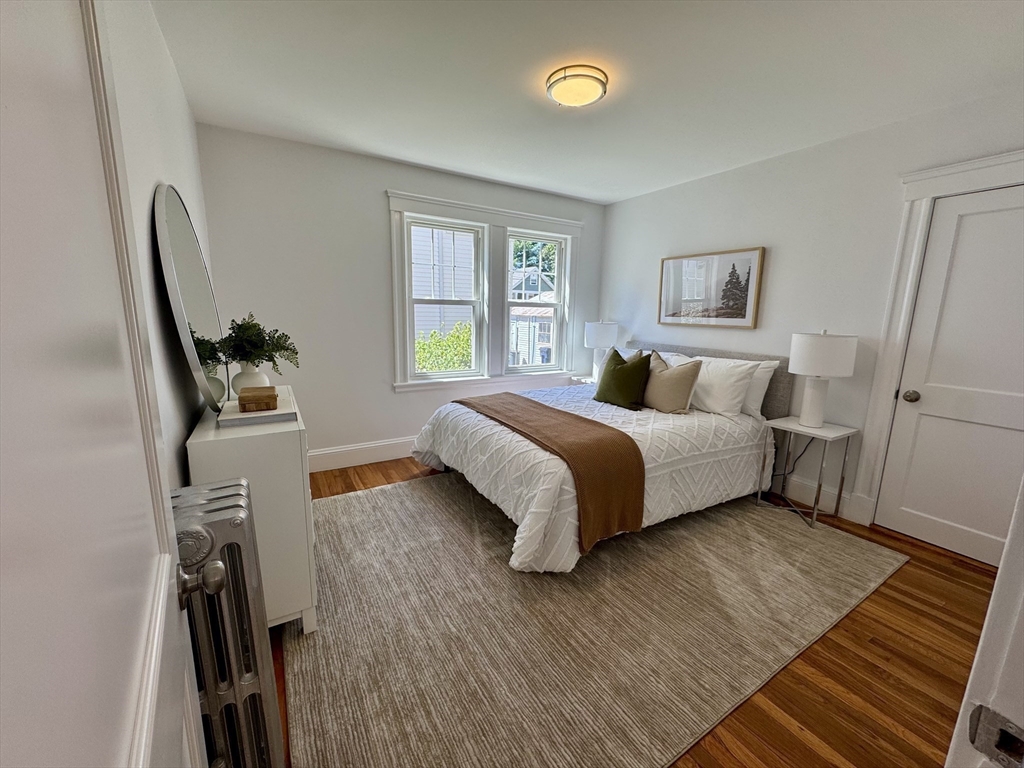 331 Vermont Street, Unit 1 Boston, MA 02132 - Photo 7 of 8 a bedroom with a bed and wooden floor