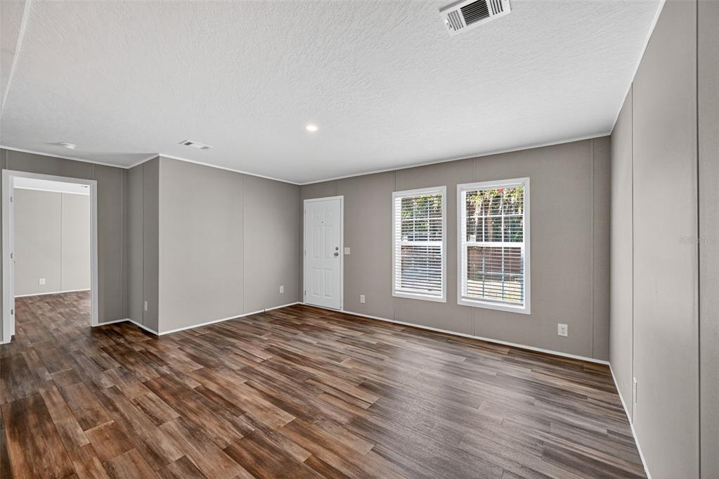 134 Weerts Road San Mateo, FL 32187 - Photo 12 of 32 a view of an empty room with wooden floor and a window