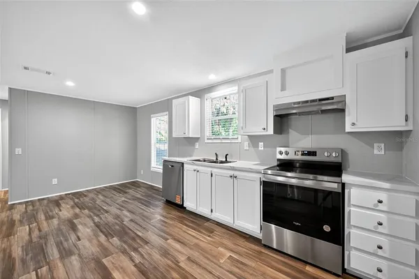 a kitchen with a stove a sink and a microwave