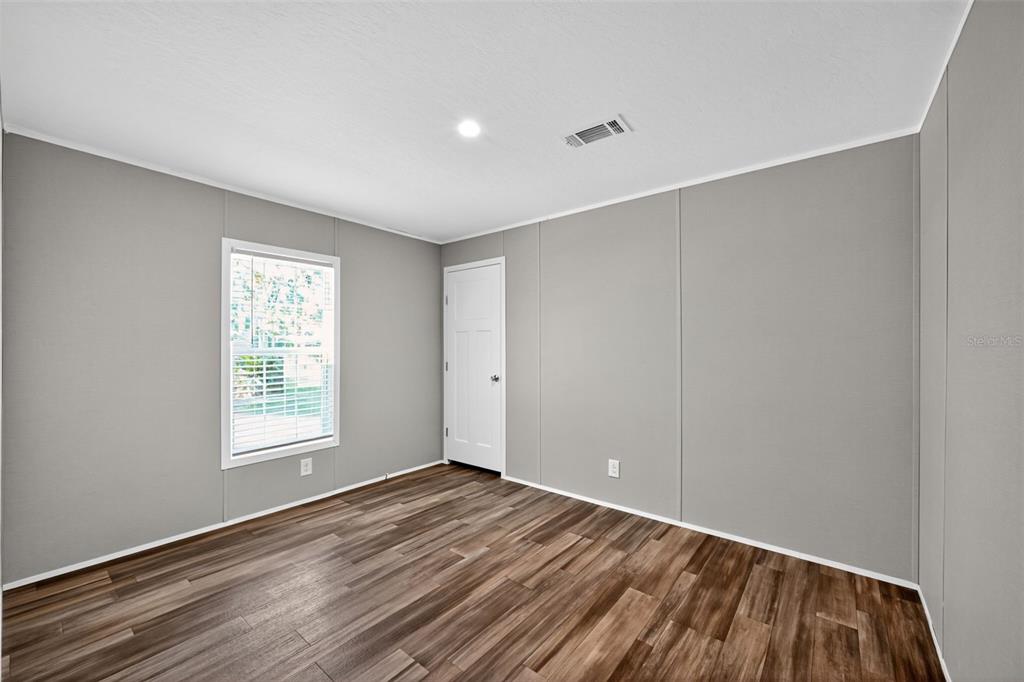 134 Weerts Road San Mateo, FL 32187 - Photo 15 of 32 a view of an empty room with wooden floor and a window
