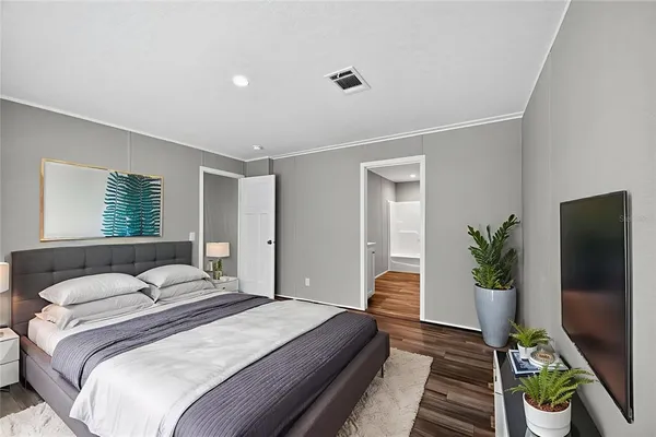 a bedroom with a bed and a potted plant